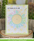 Greeting card with butterfly design and text 'Fluttering by to say' on a wooden block with plants in the background.
