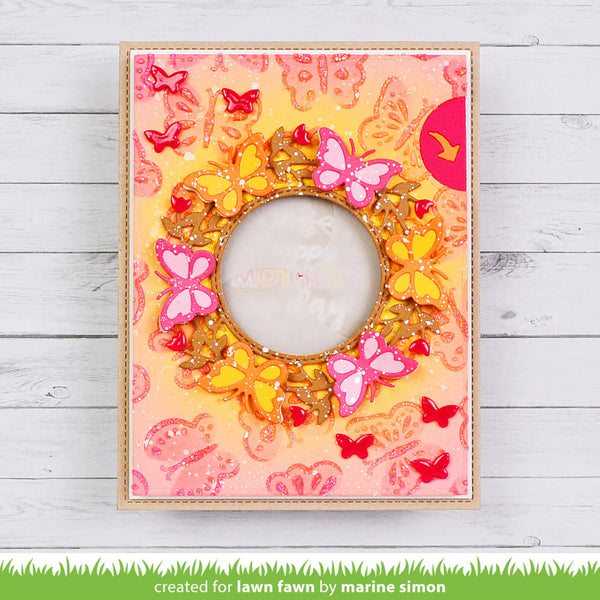 Decorative frame with butterflies and a central circular design on a wooden surface