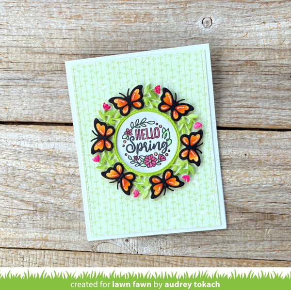 Card with butterfly design and 'Hello Spring' text on a wooden surface