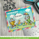 Colorful card with ducks and rainbow border on a wooden surface with stamping tools.