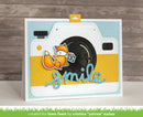 Card with a camera design featuring a fox and the word 'smile' on a wooden background.
