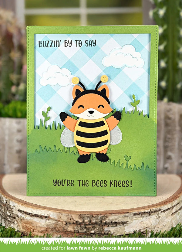 Card with a fox bee design and text on a wooden surface