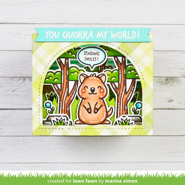 Card with a quokka illustration and text 'You quokka my world!' on a wooden surface.