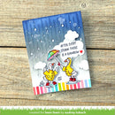 Card with cartoon ducks under an umbrella and rainbow, text 'After every storm there is a rainbow', on a wooden surface.