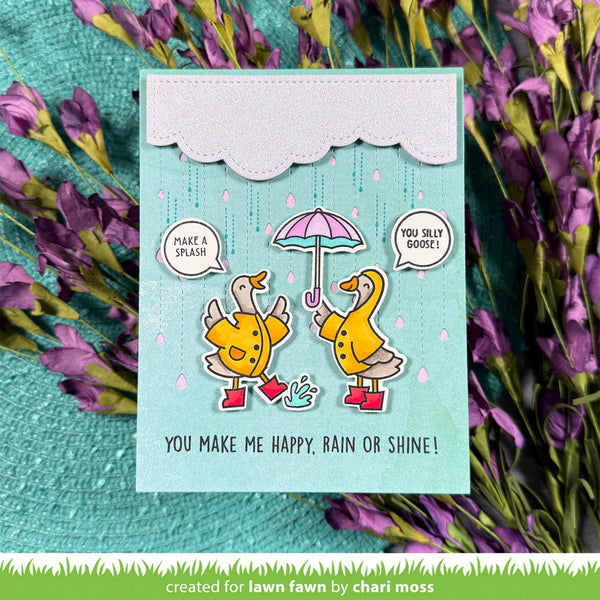 Card with cartoon ducks in raincoats and boots, surrounded by purple flowers.