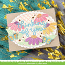 Card with floral design and 'thinking of you' text on a textured surface with flowers.