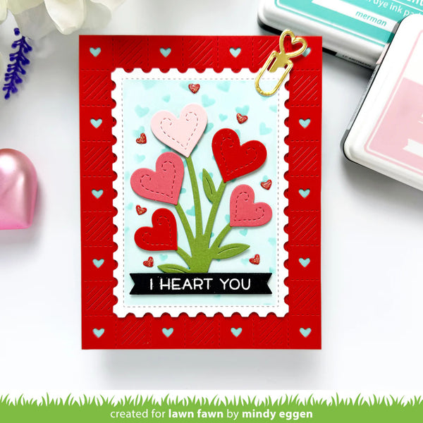 Valentine's Day card with heart design and 'I HEART YOU' text on a red border, surrounded by stamping supplies.