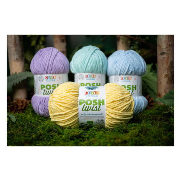 Four balls of yarn in pastel colors with 'Posh Twist' labels on a grassy background.