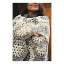 Person holding a textured, patterned blanket with a neutral color palette.