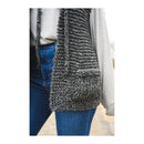 Person wearing a gray knitted hooded vest over a light-colored top and blue jeans.