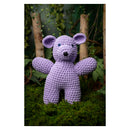 Purple crochet teddy bear on a green grass background