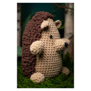 Crocheted hedgehog toy on a grassy background