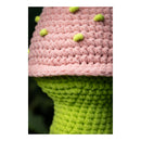 Close-up of a pink and green crocheted strawberry with green leaves.