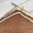 Knitted fabric with brown and beige pattern on a marble surface
