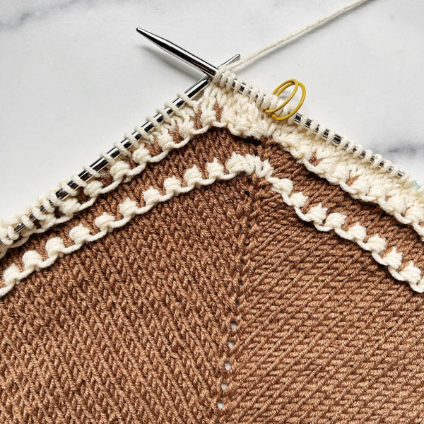 Knitted fabric with brown and beige pattern on a marble surface