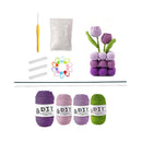 Crochet kit with yarn, hooks, and a completed purple flower on a white background