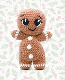 Crocheted gingerbread man amigurumi on a holly leaf christmas patterned background