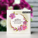 Card with floral design and text 'kindness like yours makes the world feel a little lighter and a lot brighter' by Penny Black, with blurred flowers in the background.