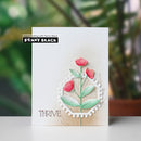 Card with floral design and 'Penny Black' branding on a blurred green background