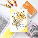 Card with floral design and text, surrounded by rubber stamps and ink pads on a white background