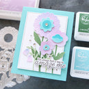 Card with floral design and message, surrounded by craft supplies on a gray background