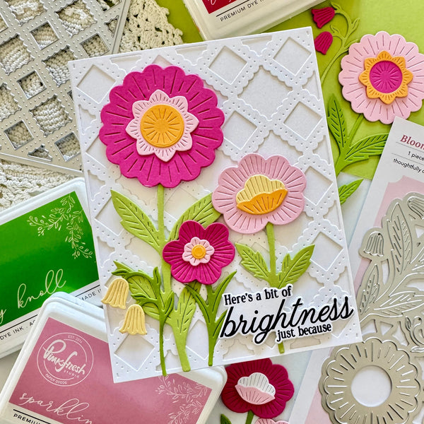 Card with floral design and text surrounded by craft supplies