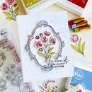 Card with floral design and 'Friends like you are everything' text, surrounded by craft supplies.