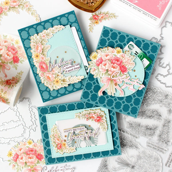 Decorative greeting cards with floral designs and text on a white surface with craft materials.
