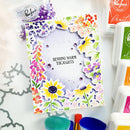 Colorful card with floral design and 'Sending Warm Thoughts' text, surrounded by craft supplies.