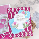 Decorative card with floral design and text on a pink background, surrounded by crafting tools.
