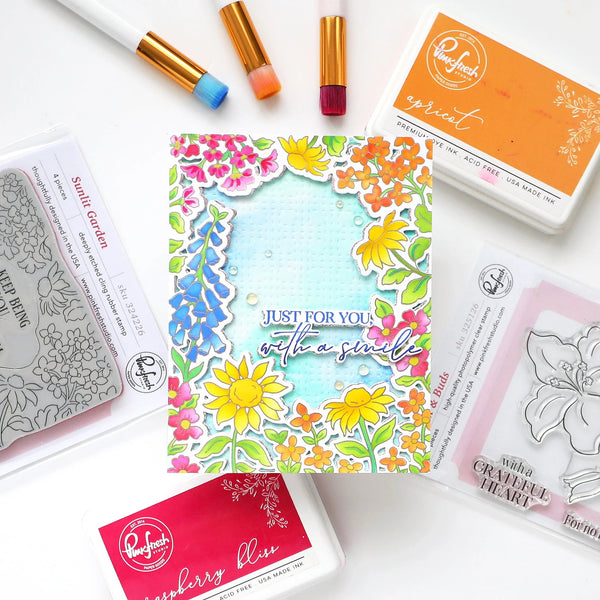 Colorful floral card with stamping tools on a white background