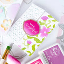 Card with floral design and 'You're so thoughtful' message, surrounded by stamping tools and ink pads.