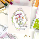 Card with floral design and text 'Friends like you are everything' surrounded by craft supplies.