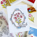 Card with floral design and 'Friends like you are everything' text, surrounded by craft supplies.