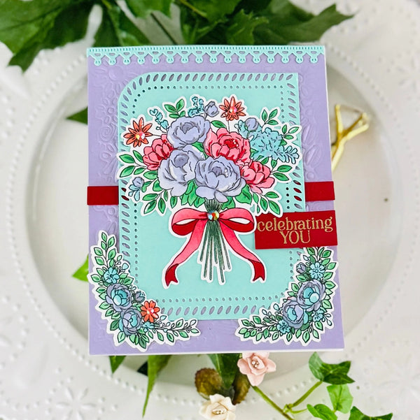 Greeting card with floral design and 'celebrating YOU' text on a white plate with green leaves.
