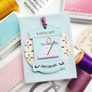 Card with decorative tag and thread spools on a white background