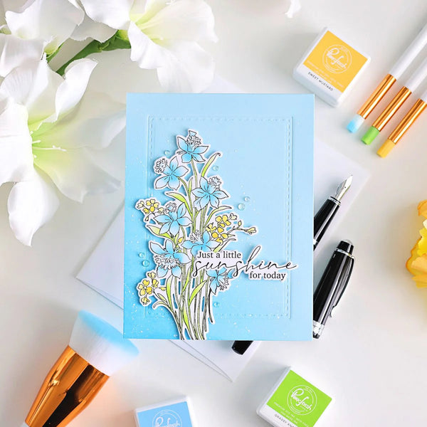 Card with floral design and text on a table with stamping supplies