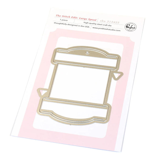 Metal craft die shaped like a spool on a pink card with branding information.