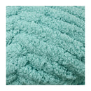 Close-up of a textured teal fabric on a white background