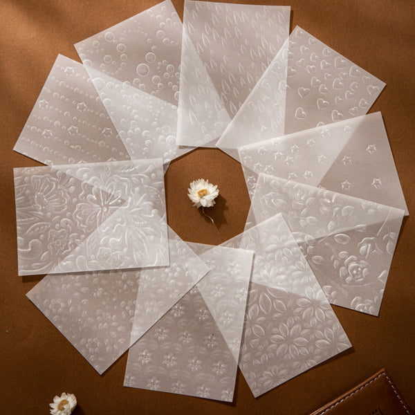 Set of white embossed cards on a brown surface with a small white flower.