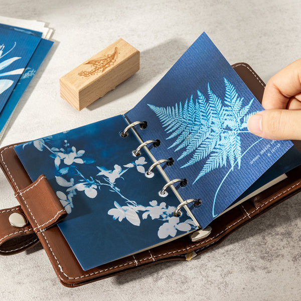Blue notebook with floral design on a gray surface