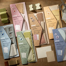 Collection of stationery items including notebooks and decorative elements on a wooden surface.