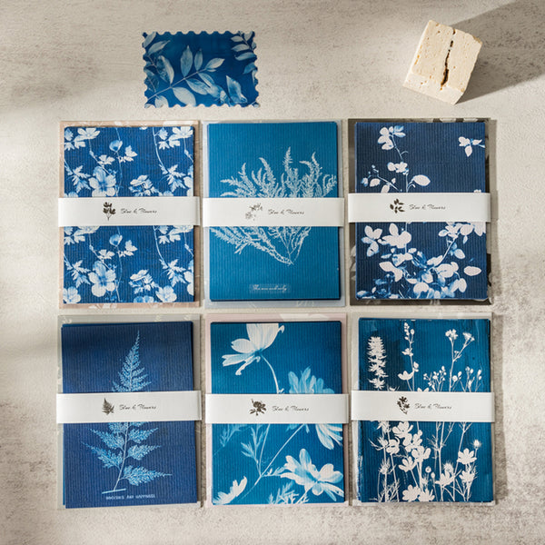 Set of blue and white floral patterned boxes on a concrete surface