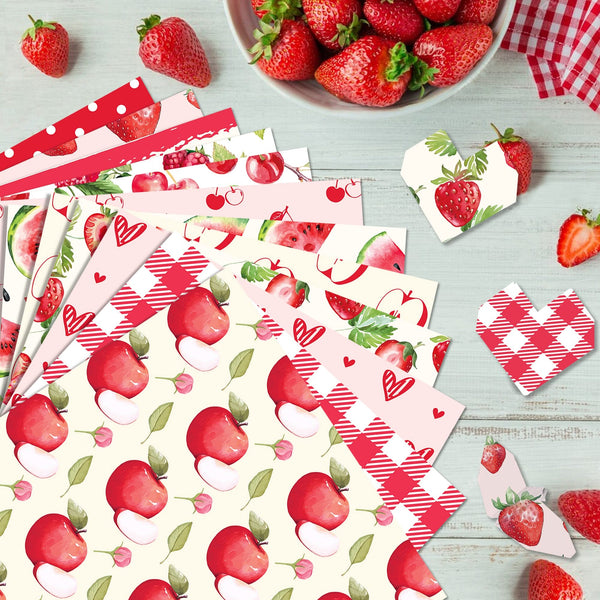 Collection of strawberry-themed paper products on a wooden surface with strawberries around.