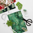 Green floral paper with scissors, ruler, and decorative elements on a white background