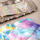 Colorful galaxy-patterned paper on a silver tray with pearls