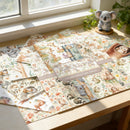 Set of animal-themed scrapbooking paper sheets on a wooden surface with a window in the background.