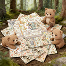Plush teddy bears and patterned paper sheets with animal illustrations in a forest setting