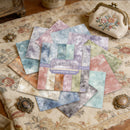 Aether scrapbooking paper sheets on a decorative surface with a small embroidered bag.