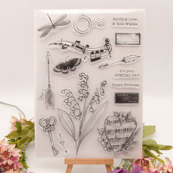 Clear stamp set with various designs including flowers, arrows, and musical notes on a white background.